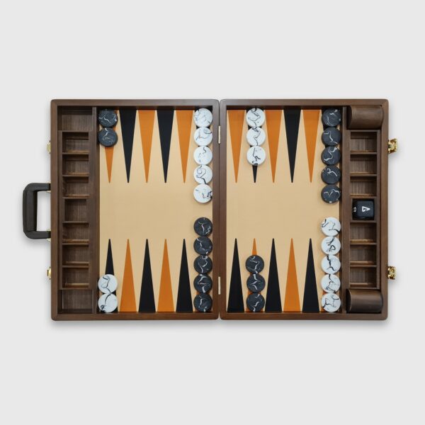 A tournament-sized Monte Carlo backgammon board with beige and brown faux leather surfaces, black and white checkers, a doubling cube, dice cups, and a handle.